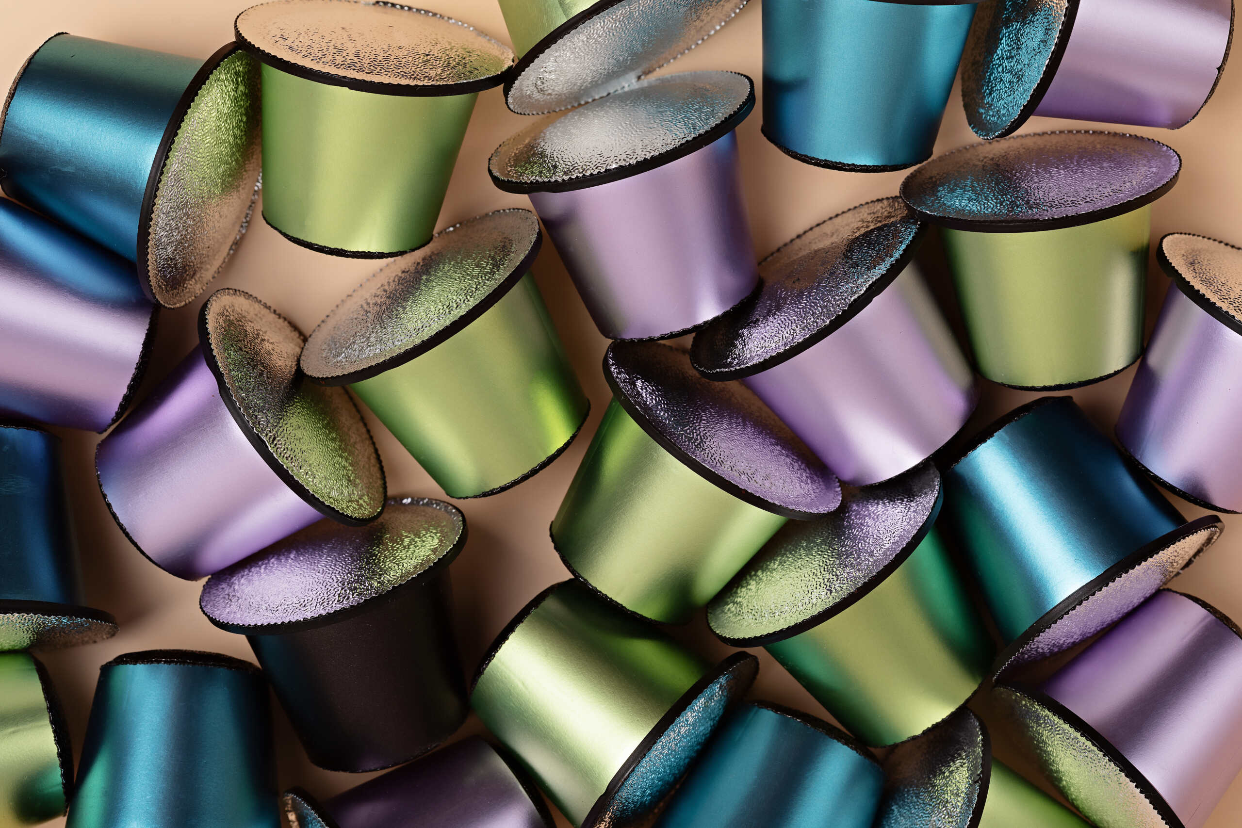 Abstract background of espresso coffee capsules of different colors and flavors.