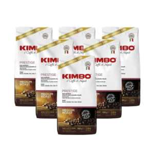 Καφές KIMBO Prestige σε κόκκους – 6 σακουλάκια του 1 κιλού, λευκή συσκευασία με χρυσή διακόσμηση, λογότυπο KIMBO σε κόκκινο χρώμα, ορατοί κόκκοι καφέ.