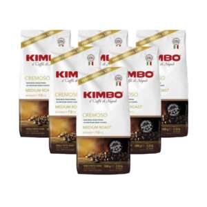 Καφές σε κόκκους CREMOSO 6x1 KG, λευκά σακουλάκια με το λογότυπο Kimbo, ορατοί κόκκοι καφέ στο κάτω μέρος, κομψός σχεδιασμός.