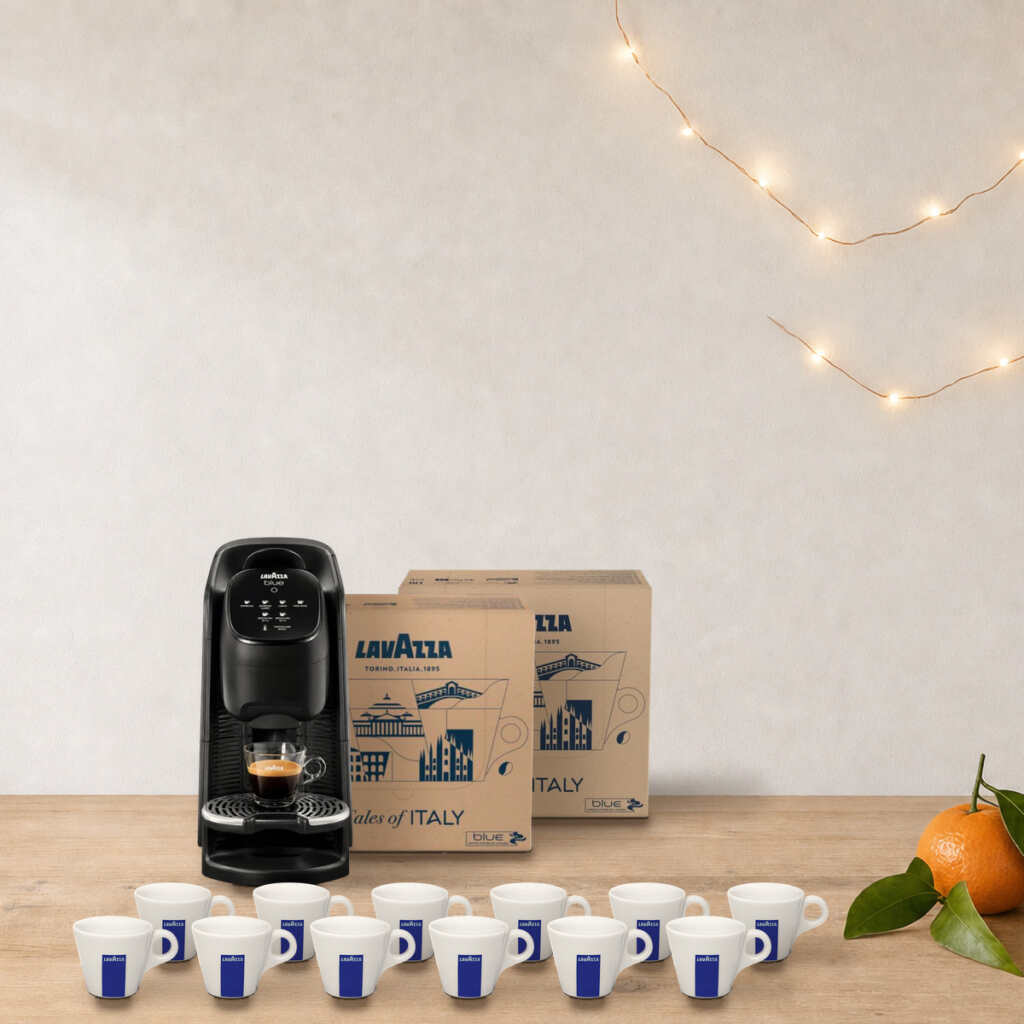 Coffret machine + cafés Lavazza Blue Classy Soul sur une table en bois, près d’une guirlande lumineuse et de clémentines