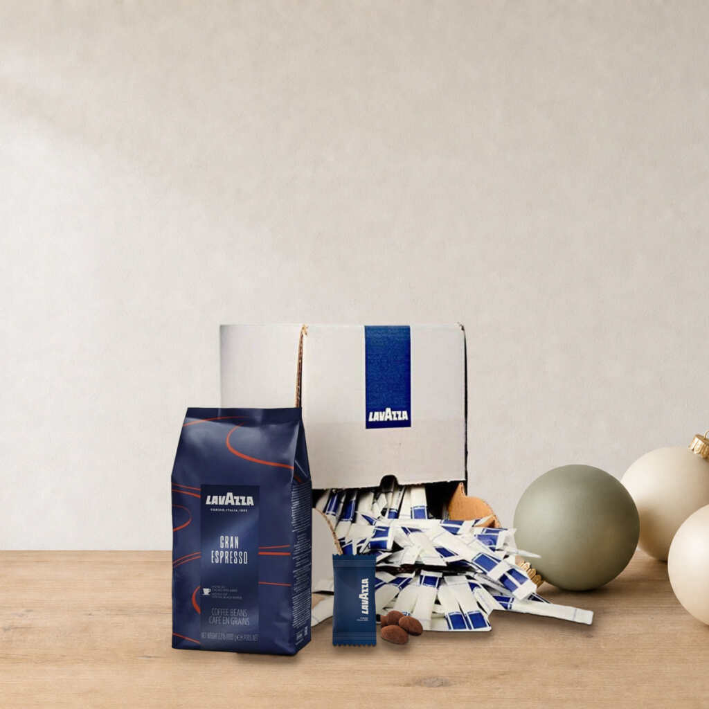 Coffret Pause café du bureau Lavazza sur une table en bois, près de boules de Noël