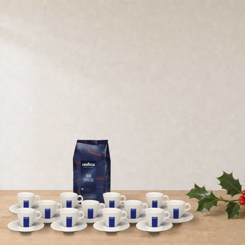 Set Espresso Lavazza sur une table en bois, près d’une branche de houx